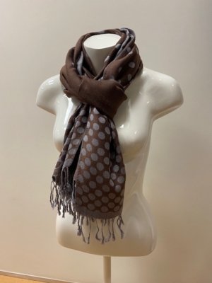 Der Schal von Kurt Beines ist aus einer Materialmischung mit Viskose-, Woll- und Alpaka-Anteil gefertigt. Er zeigt sich mit Punktmuster und kurzen Fransen.